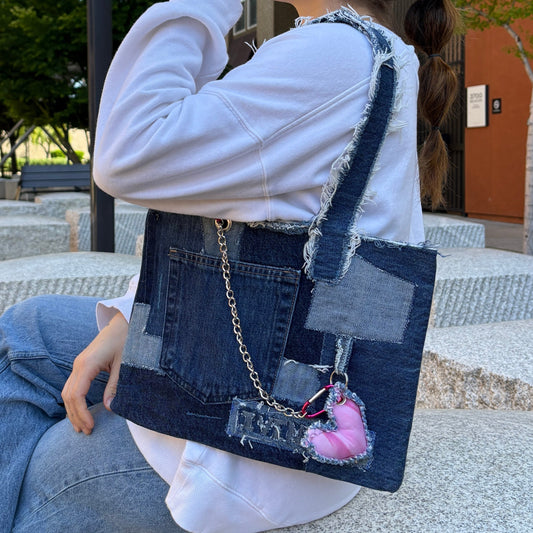 Denim Pink Handbag being worn on the shoulder, showing size and fit in an urban setting with casual denim outfit.