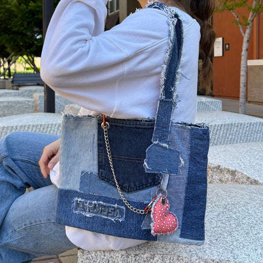 Model wearing the Denim Orange Handbag over shoulder, styled with jeans and a white sweater.