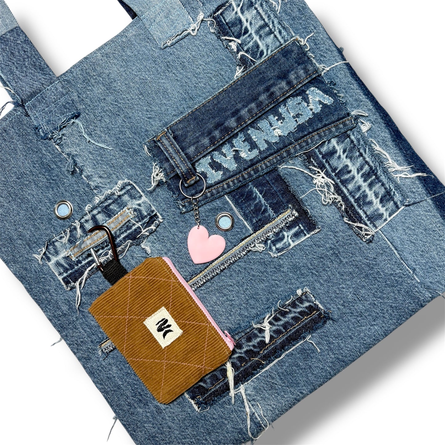Close-up of IVENUSA woven logo tag stitched onto denim fabric and brown wallet