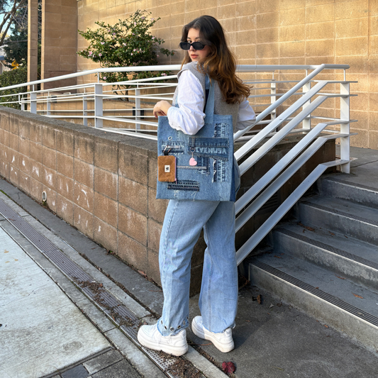 Young woman in blue jeans and grey vest wearing Ivenusa patchworked denim tote bag with brown wallet