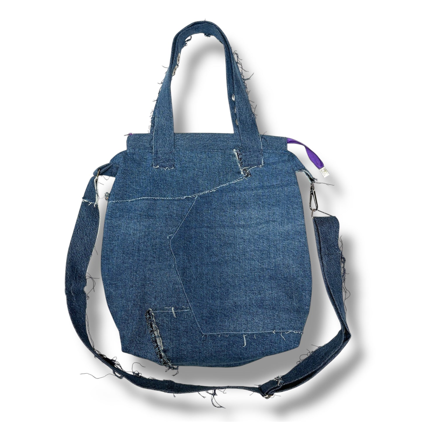 Back view of upcycled denim tote bag showing raw seam stitching and reinforced shoulder strap.