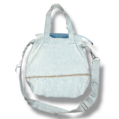 Back of IVENUSA light-wash upcycled tote bag with raw hem stitching and wide shoulder strap.