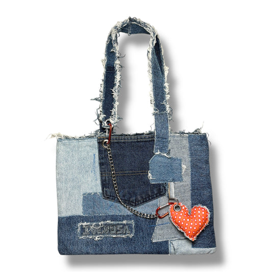 Front view of the Denim Orange Handbag featuring patchwork denim and an orange heart keychain.