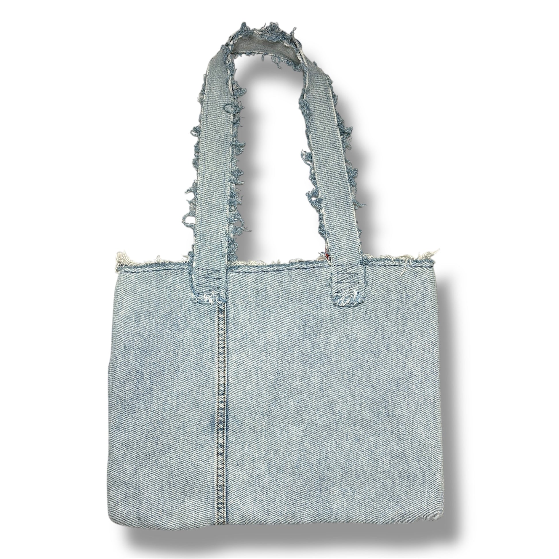Back side of the Denim Tangerine Bag showing a clean panel of light-wash denim with raw edge double handles.
