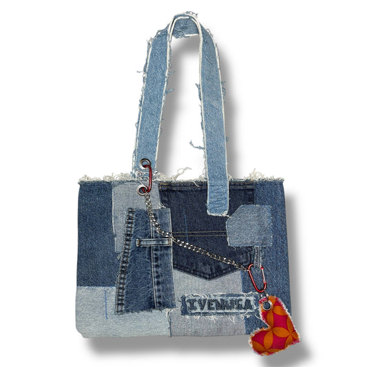 Full front view of the Denim Red Handbag made from light and dark denim patchwork with distressed trim and red keychain heart.
