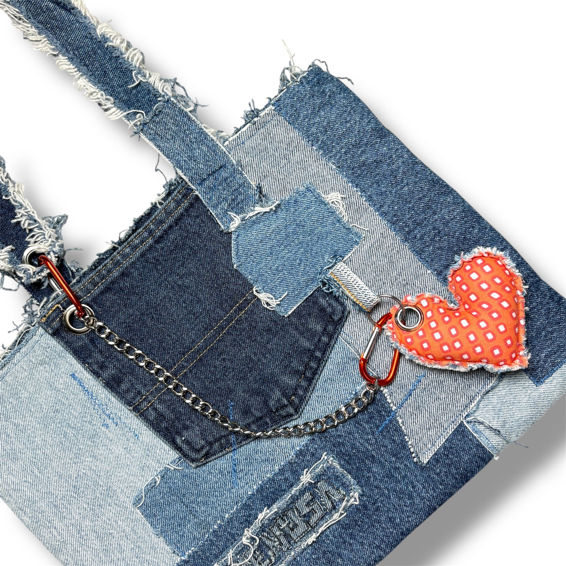 Close-up of the Denim Orange Handbag showing stitching details and heart keychain attachment.