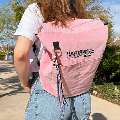 Model wearing the IVENUSA Rosé Avenue Bag on their back as a backpack while walking outdoors in jeans and a white tee.