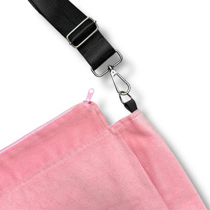 Detailed view of the Rosé Avenue Bag’s pink zipper closure and detachable black strap with silver metal hardware.