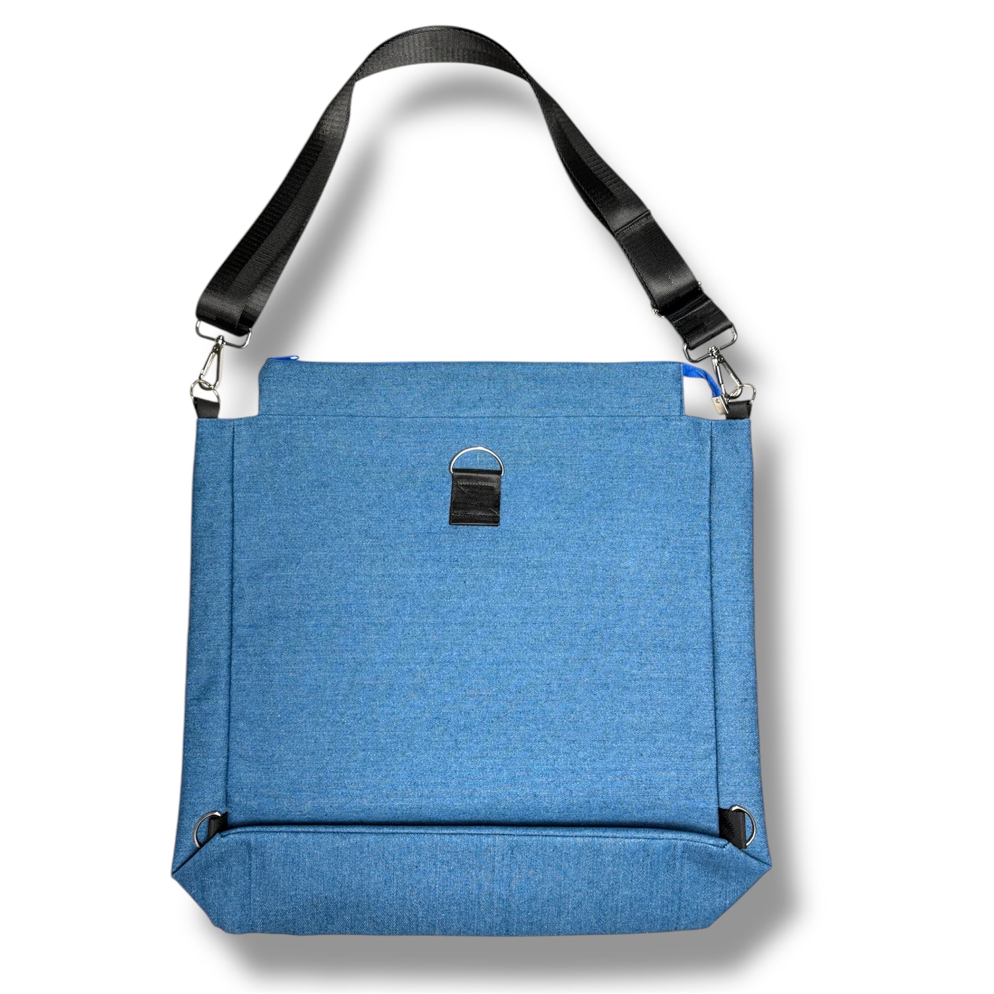 Back of the Skyline Bag by IVENUSA, showing blue fabric construction, reinforced stitching, and black adjustable shoulder strap with D-ring loop.