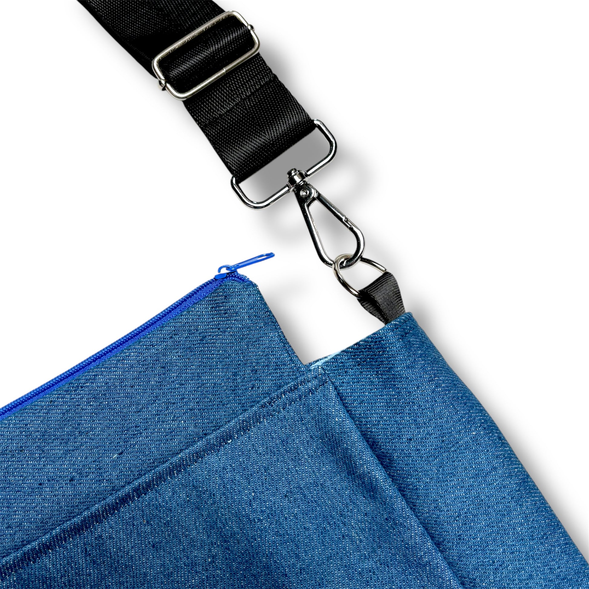 Close-up of the Skyline Bag showing vibrant blue zipper, durable stitching, and detachable black shoulder strap with metal hardware.