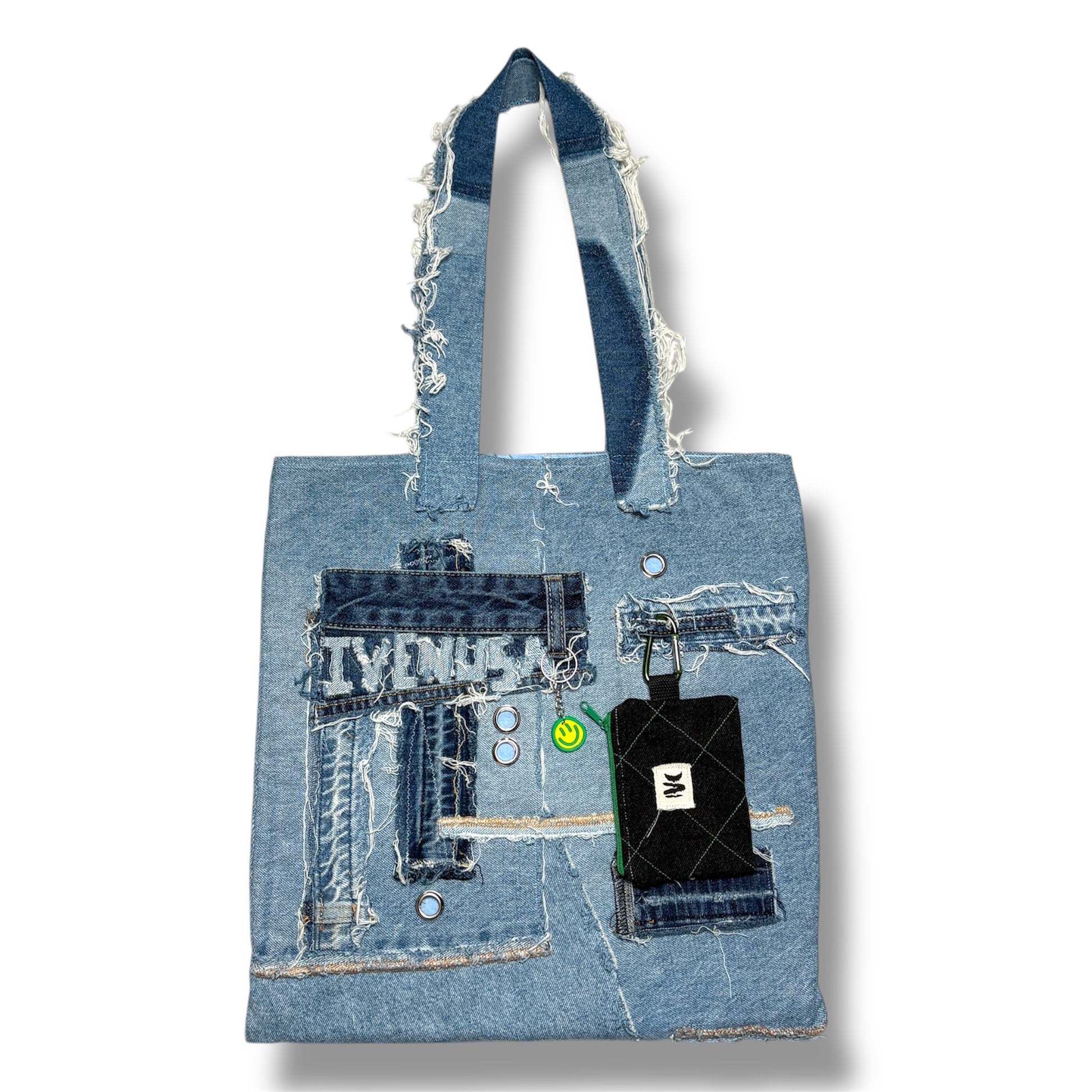 Front view of the Iconic Green patchwork denim tote bag featuring frayed textures, silver grommets, and a detachable black wallet with green zipper.
