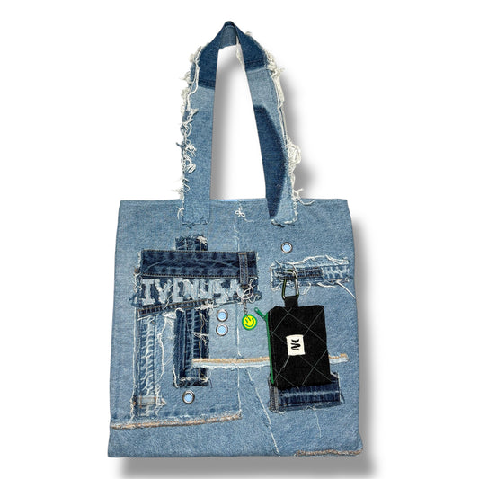 Front view of the Iconic Green patchwork denim tote bag featuring frayed textures, silver grommets, and a detachable black wallet with green zipper.