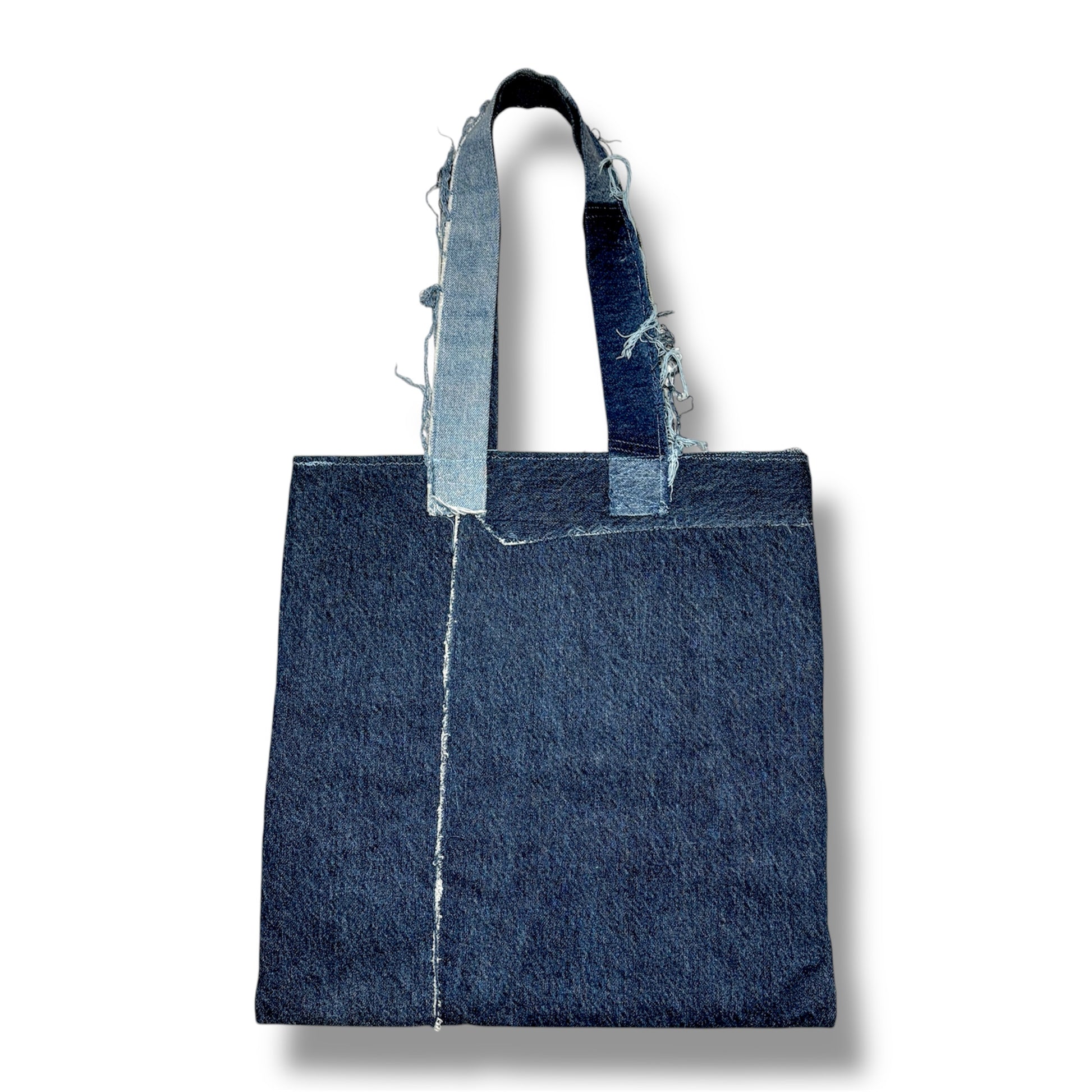 Backside of handmade denim tote bag featuring boho-style patches
