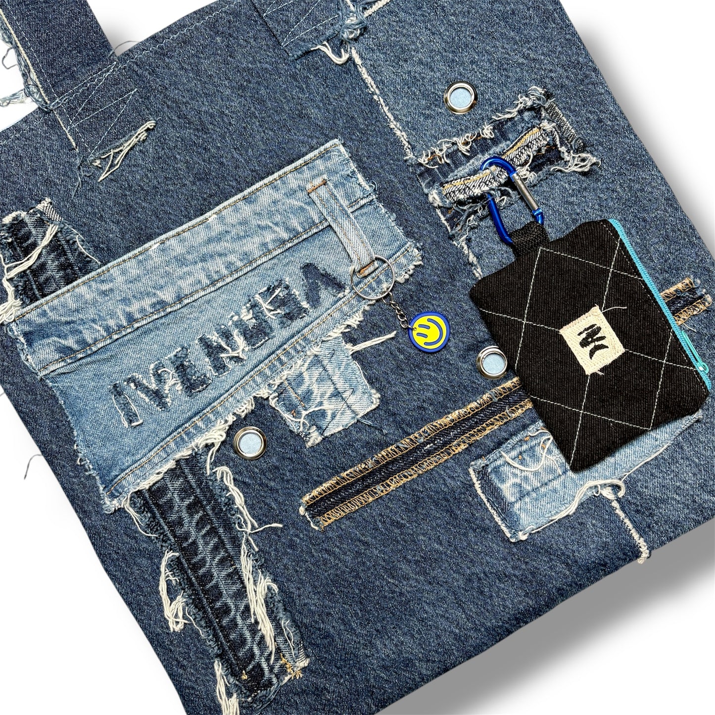Close-up of IVENUSA woven logo tag stitched onto denim fabric and black wallet