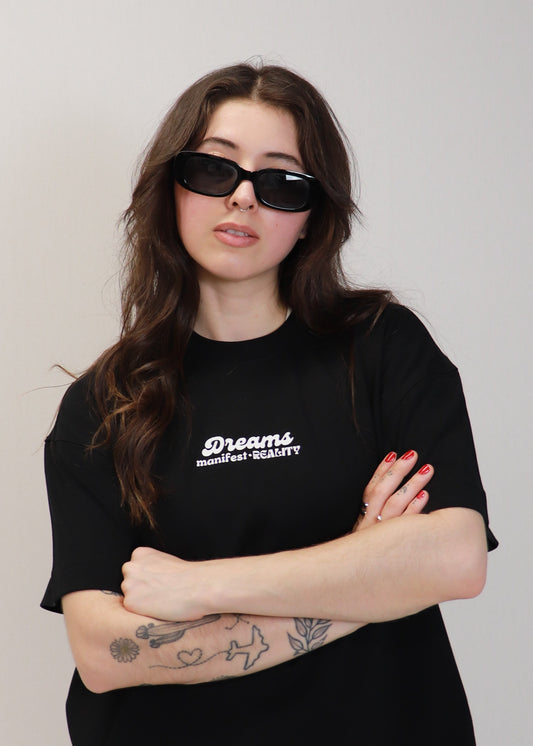 Close front view of black DMR oversized t-shirt worn by female model