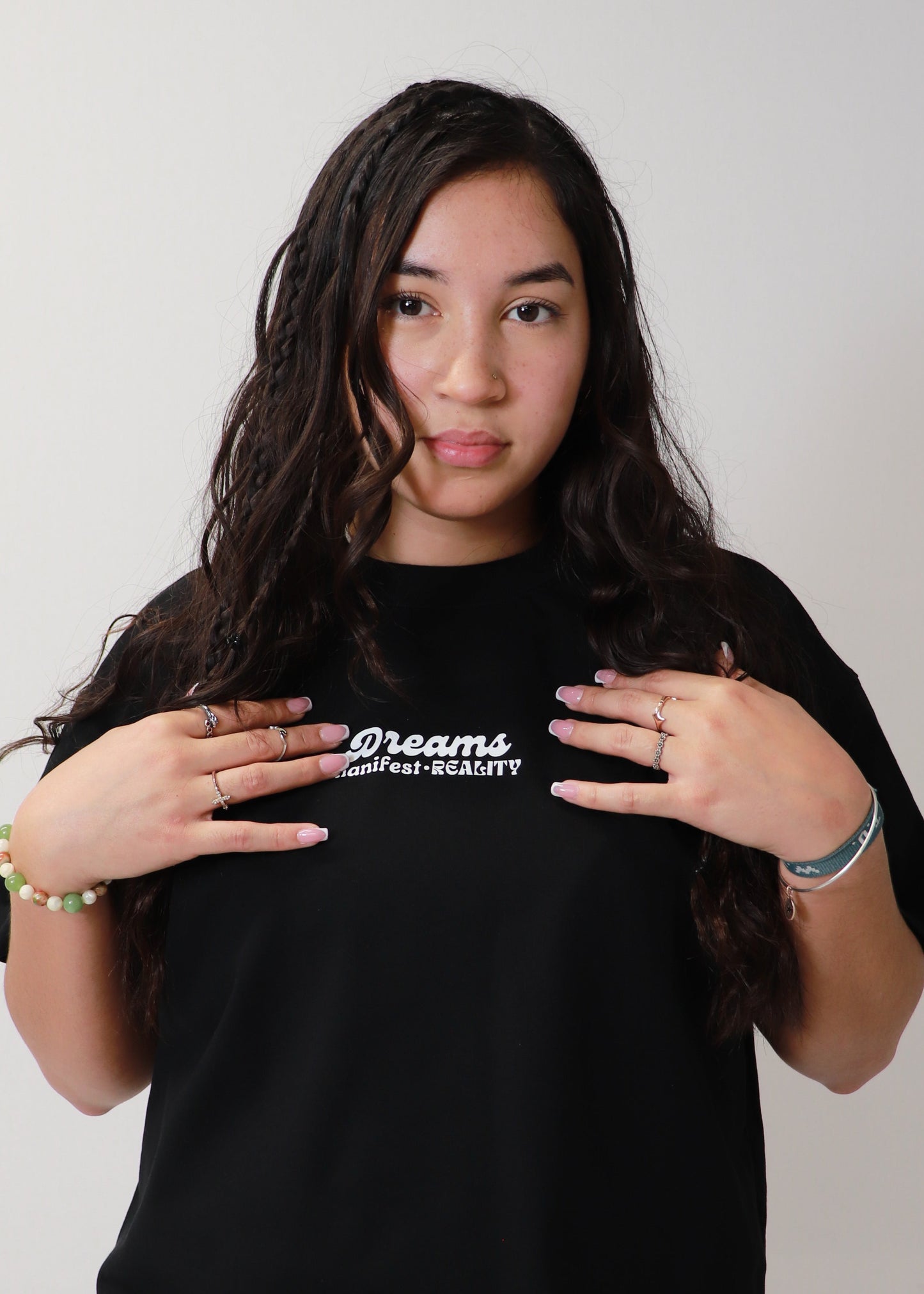 Female model pointing at logo on black DMR oversized t-shirt