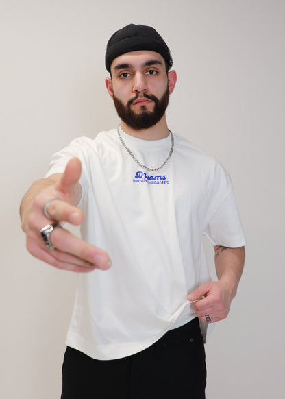 Male model gesturing while wearing white DMR oversized boxy tee