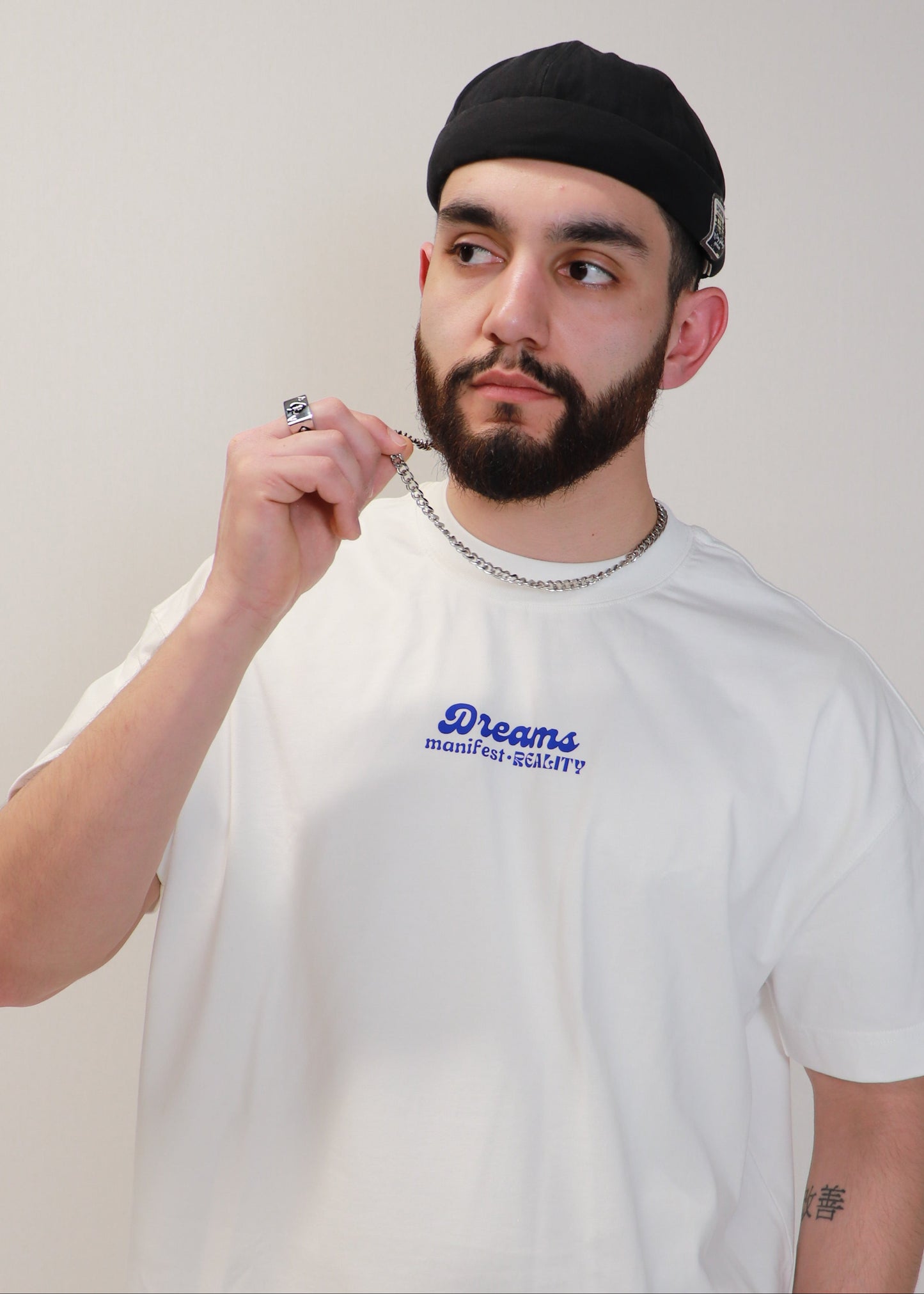 Male model posing while wearing white DMR oversized t-shirt