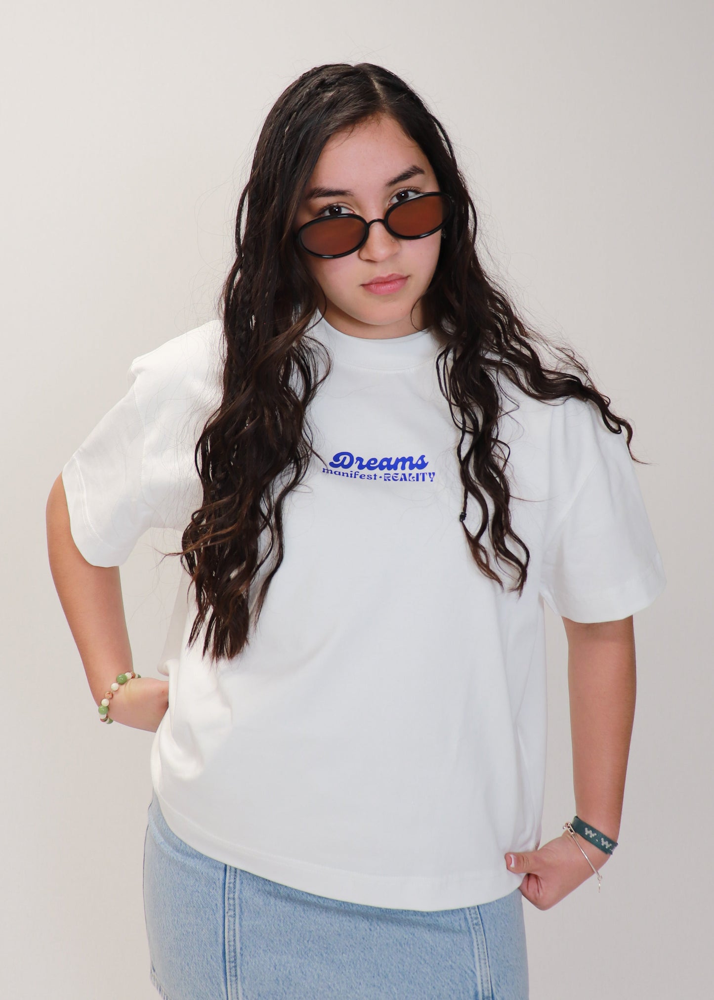 Female model styling white DMR oversized boxy tee with sunglasses